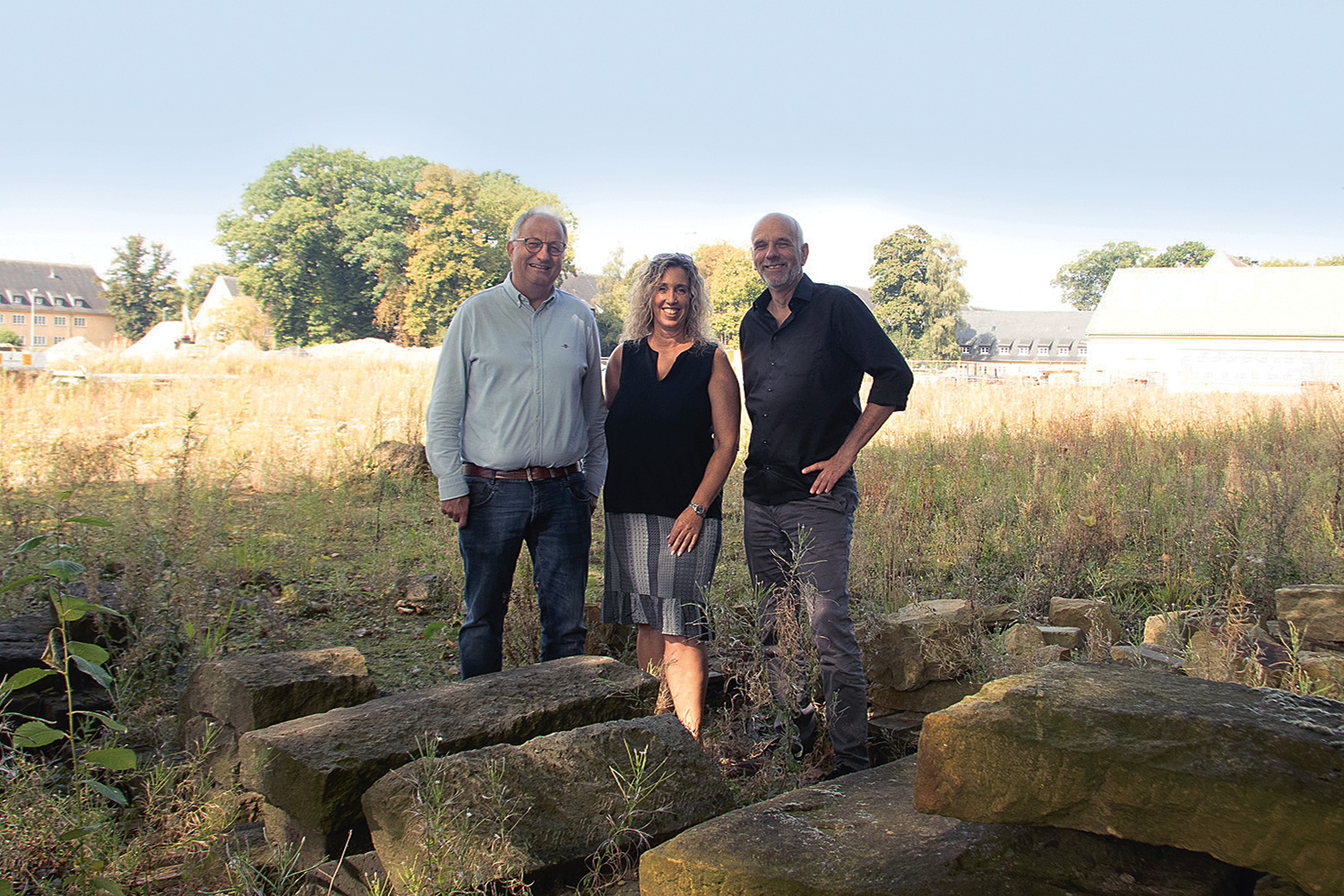 Drei Personen auf einem leeren Baufeld