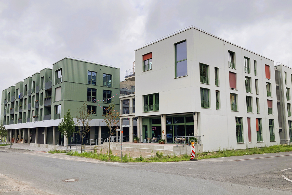 Ein grünes Gebäude links und ein weißes Gebäude rechts